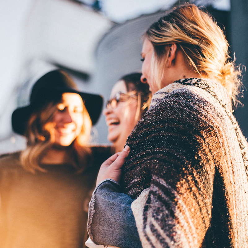 Drei Frauen stehen zusammen und lachen